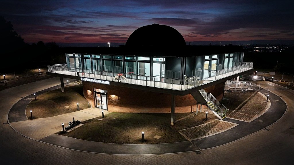 Sherwood Observatory planetarium at dusk: circular brick base, square upper deck and dome